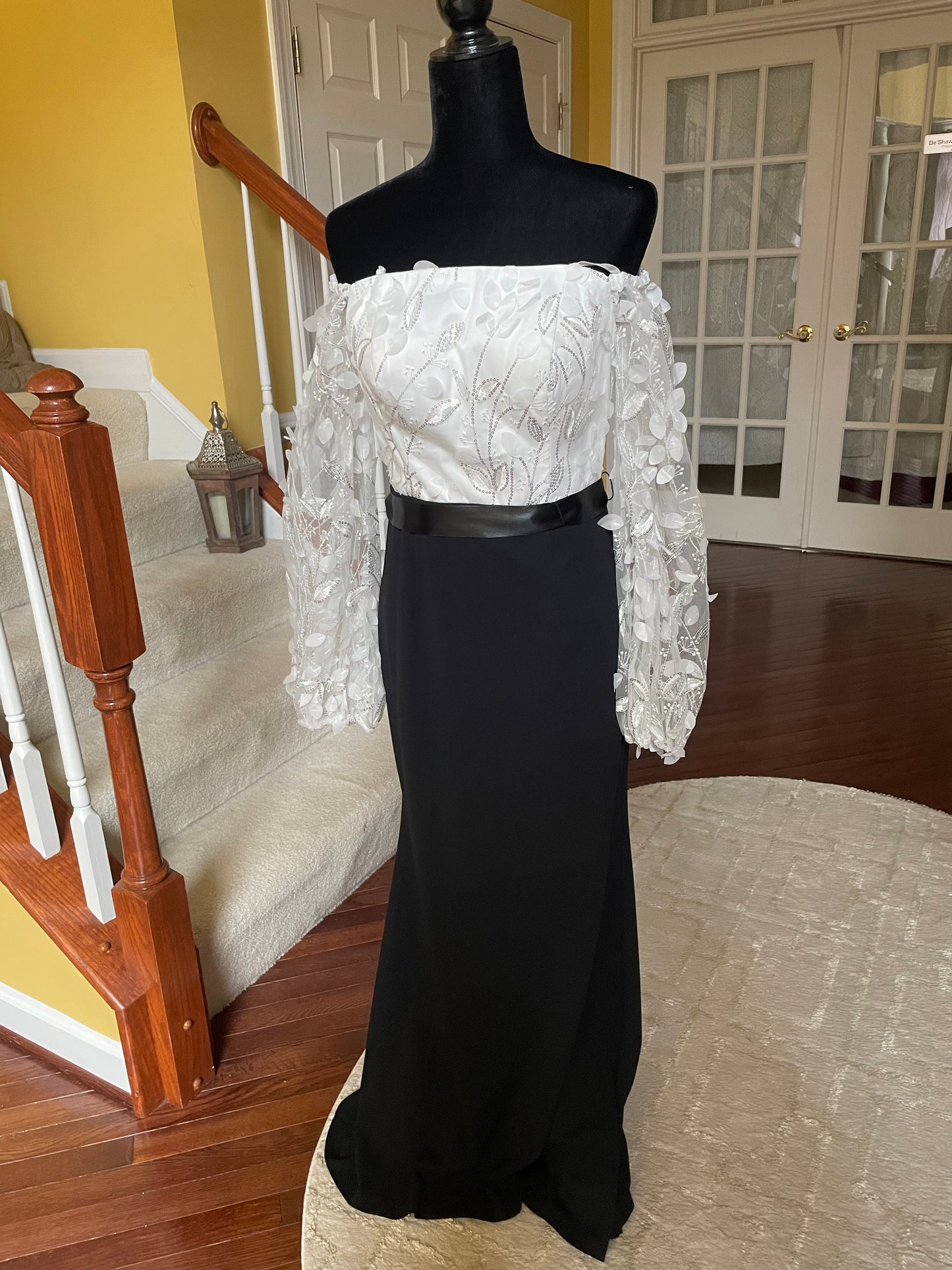 0726 SIZE:8 ELIZA J BLACK&WHITE FLOATING PETALS LNG SLV GOWN W/LEAF APPLIQUE & SILVER SEQUIN SHEER SLVS AND WHITE BODICE, GATHERED SHOULDERS, CONCEALED BACK ZIPPER, LNG BLACK SKIRT, AND SATIN BELT NWOT RTL:$188.00